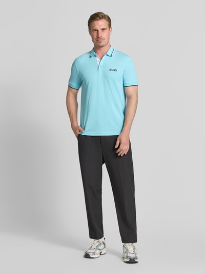 Mężczyzna nosi koszulkę polo Regular Fit z mieszanki bawełny model 'PADDY PRO' od BOSS Green w jasnoniebieskim kolorze, widok całej sylwetki z przodu.