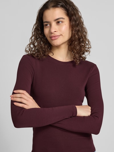 Frauenmodel trägt Regular Fit Langarmshirt aus Baumwoll-Mix Modell 'RILEY' von ONLY in Dunkelrot, glatte Textur, Nahaufnahme Oberkörper, Damen Langarmshirt von ONLY.