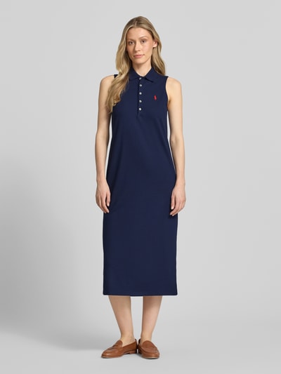 Frauenmodel trägt Figurumschmeichelndes Polokleid aus Baumwolle-Mix von Polo Ralph Lauren in Optik: Unifarben, Midi-Länge, Piqué-Struktur, Logo-Stitching, Seitenschlitz, ganzkörperansicht von vorne.