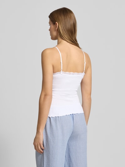 Frauenmodel trägt Slim Fit Top aus Viskose-Mix mit Spitzenbesatz von Review in Weiß, Spaghettiträger, Ganzkörperansicht Rückansicht. Rückenlänge bei Größe S: 36 cm, elastischer Viskose-Mix, glatte und zarte Textur.