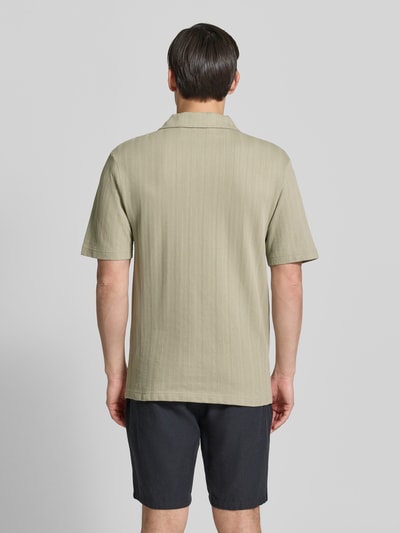 Männermodel trägt Relaxed Fit Poloshirt mit Strukturmuster Modell 'DALIBO' von HUGO, Optik: Unifarben, reine Baumwolle, Ganzkörperansicht Rückansicht.