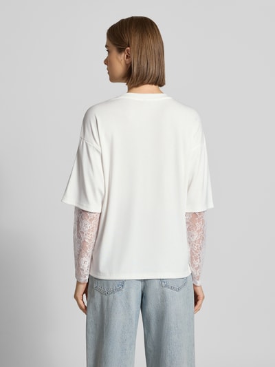 Frauenmodel trägt Regular Fit Langarmshirt mit Viskose-Anteil Modell 'TAHLIA' von ONLY, Weiß, Spitzendetails, Damen Langarmshirt, Ganzkörperansicht Rückansicht.