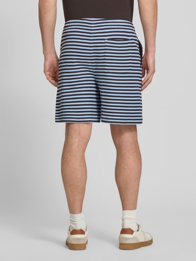 Männermodel trägt Regular Fit Sweatshorts aus Baumwoll-Mix von Lacoste mit Allover-Streifenmuster, elastischem Bund, Gesäßtasche, Ganzkörperansicht Rückansicht.