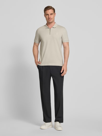 Männermodel trägt Slim Fit Poloshirt aus Baumwoll-Mix Modell 'PASSERZIP' von BOSS Orange, Optik: Unifarben, Ganzkörperansicht von vorne.