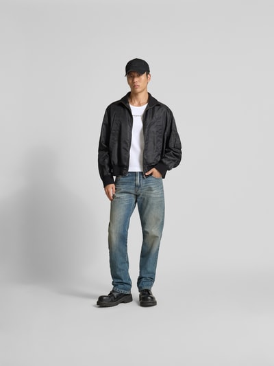Männermodel trägt Top aus reiner Baumwolle von MAISON KITSUNÉ in Weiß mit Ripp-Optik, Label-Detail, eng anliegender Passform, Ärmelloses-Design, Rückenlänge bei Größe M 61 cm, Ganzkörperansicht von vorne.