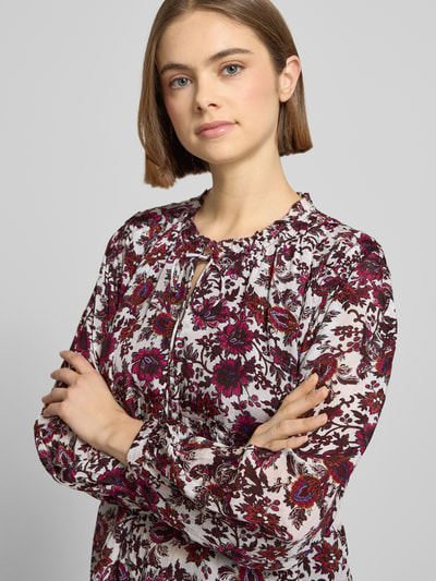 Frauenmodel trägt Oversized Langarmbluse aus reiner Viskose Modell 'LUCILA' von Pepe Jeans, floral gemustert, Rüschenkragen, Nahaufnahme Oberkörper.