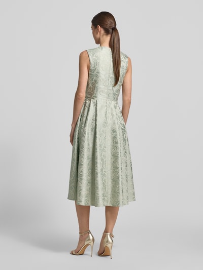 Männermodel trägt Regular Fit Midikleid mit floralem Allover-Stitching von Rinascimento, miętowy kolor, bez rękawów, krój regular fit, dekolt w serek, fałdy, zamek, długość tyłu w rozmiarze S: 97 cm, szerokość w rozmiarze S: 40 cm, całkowity widok z tyłu.