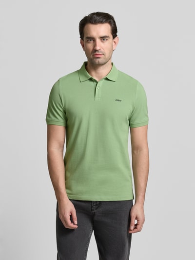 Mannenmodel draagt Regular Fit Poloshirt aus reiner Baumwolle van s.Oliver RED LABEL, lichtgroen, uni, korte mouw, piqué stof, voorkant bovenlichaam close-up.