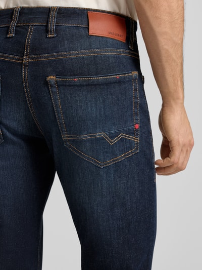 Männermodel trägt Jeans met steekzakken, model 'ARNE PIPE' van MAC, donkerblauw katoenmix, slim fit, detailopname achterkant.