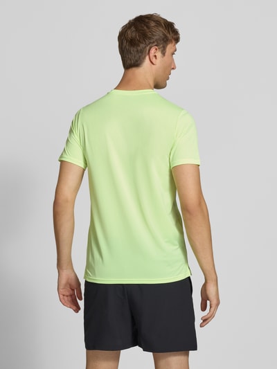 Männermodel trägt Funktionsshirt mit Rundhalsausschnitt und Logo von New Balance, hellgrün, glatte Textur, Regular Fit, Rückenlänge 69 cm, Ganzkörperansicht Rückansicht.
