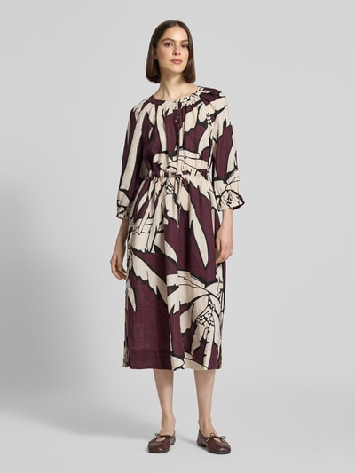 Frauenmodel trägt Midikleid aus reinen Leinen mit floralem Allover-Print von Christian Berg Woman in Creme und Bordeaux, taillierte Passform, Rundhalsausschnitt, 3/4-Arm, Knopfleiste, Ganzkörperansicht von vorne.