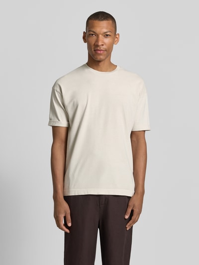 Männermodel trägt T-Shirt mit Ärmelaufschlag und Rundhalsausschnitt von Drykorn, Reine Baumwolle, Regular-Fit, Rückenlänge 70 cm, Ganzkörperansicht von vorne.