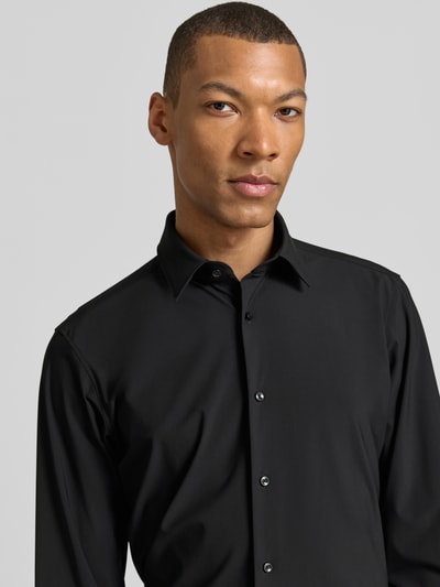 Männermodel trägt Regular Fit Businesshemd mit Kentkragen Modell 'JOE' von BOSS, Optik: Unifarben, Materialverarbeitung: Performance-Stretch-Jersey, Nahaufnahme Oberkörper.