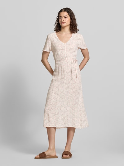 Frauenmodel trägt A-Linien Midikleid aus reiner Viskose Modell 'BARRI' von Pieces, Optik:Allover-Muster, A-Linie, Midi-Länge, Rundhals, Knopf-Verschluss, Ärmelform: Ohne, Material: reine Viskose, Farben in zarten Pastelltönen, feines florales Muster, fließende Textur, Ganzkörperansicht von vorne.