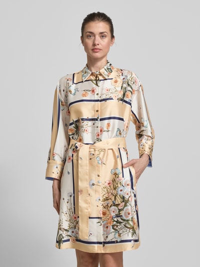 Frauenmodel trägt Knielanges Kleid mit floralem Allover-Print von Liu Jo White aus leicht glänzendem Satin, taillierte Passform, Umlegekragen, langärmelige Passform, Logo-Print, Knopfleiste und abnehmbarem Stoffband, helle Farben mit floralen und geometrischen Mustern, Nahaufnahme Oberkörper.