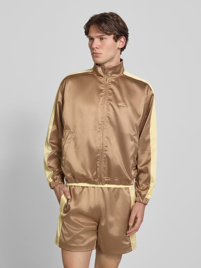 Männermodel trägt Schimmernde Trainingsjacke mit Label-Stitching von BLKVIS in Regular-Fit, Stehkragen, Reißverschluss, Ganzkörperansicht von vorne.