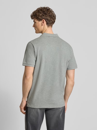 Männermodel trägt Regular Fit Poloshirt mit Label-Stitching von Carhartt Work In Progress in Grau, Baumwolle, Rückansicht, Ganzkörperansicht.