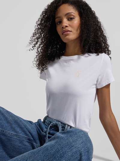 Kobiece modelka nosi damski t-shirt Regular Fit T-Shirt aus reiner Baumwolle Modell 'C_ELOVE_1' od BOSS Orange, efekt: jednolity kolor, wyhaftowane logo i motyw, okrągły dekolt, krótki rękaw, dżersej, czysta bawełna, ujęcie z przodu, zbliżenie na górną część ciała.