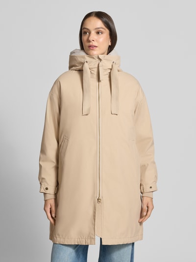 Vrouwenmodel draagt Regular fit lange jas met tweewegritssluiting Model 'Joy' van g-lab in beige, met capuchon met tunnelkoord, elastische mouwboorden, ruglengte maat S 94 cm, schouderbreedte 57 cm, borstwijdte 64 cm, mouwlengte 57 cm, vooraanzicht van het volledige lichaam.