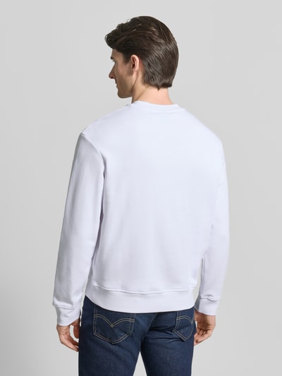 Męski model nosi Sweatshirt mit Logo-Print und Rundhalsausschnitt od ARMANI EXCHANGE, czysta bawełna, krój loose fit, widok całej sylwetki od tyłu.