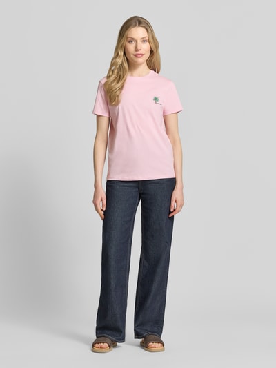 Kobiece model nosi t-shirt z wyhaftowanym motywem od Jake*s Casual, bawełna, krój regular fit, okrągły dekolt, długość tyłu w rozmiarze S: 61 cm, kolor różowy, prosta faktura, widok całej sylwetki z przodu.