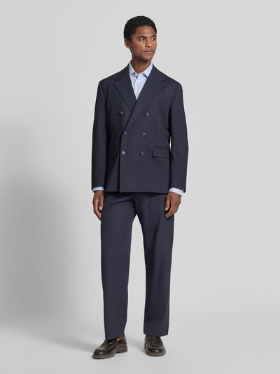 Männermodel trägt dunkelblaues Relaxed Fit Anzugsakko mit Viskose-Anteil Modell 'LIAM' von Selected, Ganzkörperansicht von vorne. Unifarbene Optik, Regular Fit, Reverskragen, zweireihige Knopfleiste, Rückenschlitz, Brustleistentasche und Pattentaschen.