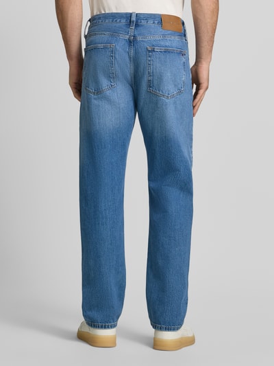 Mannenmodel draagt Straight Fit Jeans aus van Tommy Hilfiger in blauwe denim met lichte wassingen, herenjeans, volledig lichaam achteraanzicht.