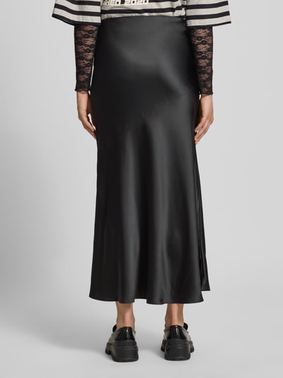 Frauenmodel trägt Satinrock mit elastischem Bund von Gina Tricot in Schwarz, Gerader-Schnitt, Maxi, Satin-Haptik, Ganzkörperansicht Rückansicht.