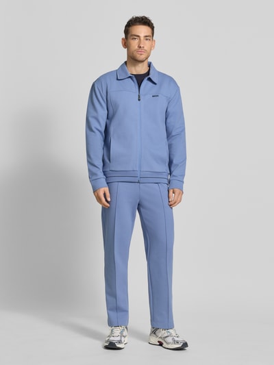 Männermodel trägt Regular Fit Sweatjacke aus Baumwoll-Mix Modell 'SW_Member' von BOSS Green in Blau mit Reißverschluss, Ganzkörperansicht von vorne.