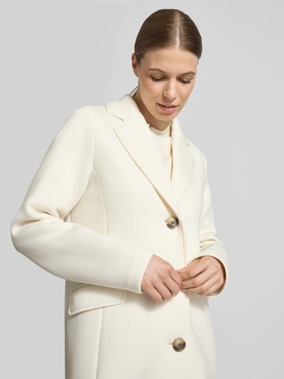 Modelka prezentuje Płaszcz mit Kapuze und Pattentaschen von Christian Berg Woman Selection, mieszanka materiałów z dodatkiem wiskozy, krój regular fit, kaptur z tunelem, listwa guzikowa, kieszenie z patką, długość tyłu w rozmiarze 36: 88 cm, szerokość ramion w rozmiarze 36: 45 cm, szerokość w rozmiarze 36: 50 cm, długość rękawów w rozmiarze 36: 57 cm, kremowy kolor, gładka faktura, zbliżenie na górną część ciała