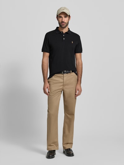 Męski model nosi Poloshirt mit Label-Stitching von Polo Ralph Lauren, bawełna, krój regular fit, kołnierzyk polo, krótka plisowana stójka, label-stitching, prążkowane rękawy, długość tyłu w rozmiarze M: 69 cm, widok całej sylwetki z przodu.