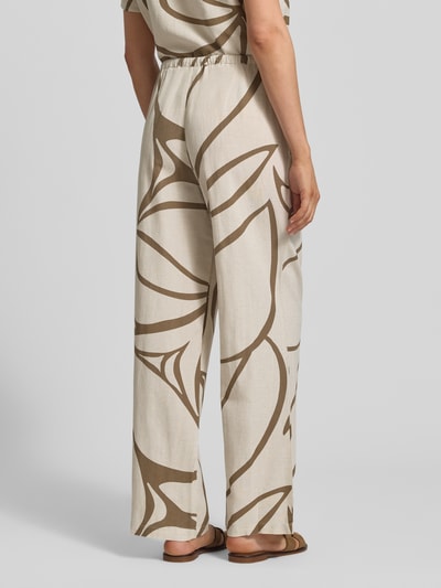 Frauenmodel trägt Stoffhose aus Viskose-Mix Modell 'PRISILLA' von Vila mit Leinen-Viskose-Anteil, Wide-Leg, Eingrifftaschen, Tunnelzug, cremefarben mit braunem Muster, Ganzkörperansicht Rückansicht.