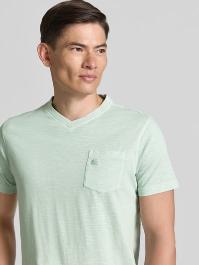 Männermodel trägt Regular Fit T-Shirt mit V-Ausschnitt von Lerros in Hellgrün, reine Baumwolle, Logo-Stitching, Nahaufnahme Oberkörper.