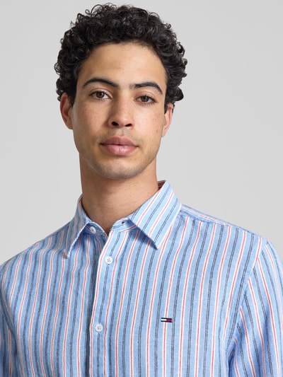 Männermodel trägt Regular Fit Freizeithemd aus Leinen-Baumwoll-Mix von Tommy Jeans, gestreift, mehrfarbig, Nahaufnahme Oberkörper.