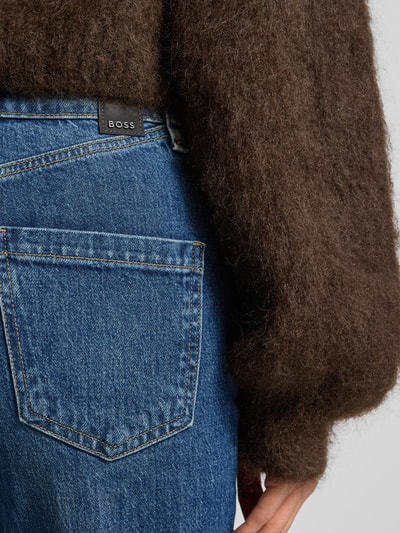 Frauenmodel trägt Straight Fit Jeans aus Baumwoll-Mix Modell 'PARKWAY' von BOSS in Blau mit Label Patch und 5-Pocket-Design, Nahaufnahme Rückansicht.