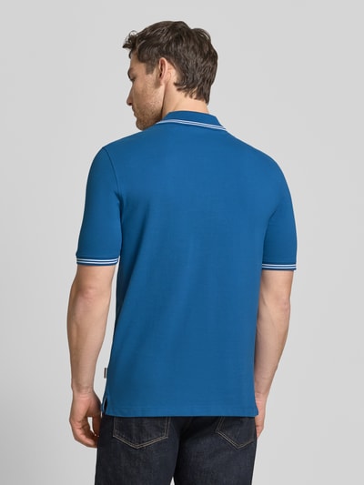 Männermodel trägt Regular Fit Poloshirt mit Logo-Stitching von bugatti in Blau, Reine Baumwolle, Polokragen, Rückenlänge 71 cm, Ganzkörperansicht Rückansicht.