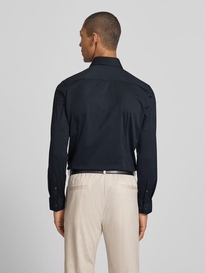 Männermodel trägt Slim Fit Business-Hemd mit Haifischkragen von SEIDENSTICKER, Material-Mix mit Stretch-Anteil, Ganzkörperansicht Rückansicht.