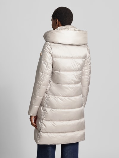 Frauenmodel trägt Steppmantel mit Kapuze Modell 'LYSA' von Save The Duck in hellem Beige, gesteppte Struktur, gerader Schnitt, Rückenansicht.