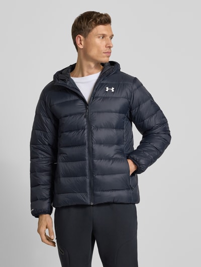 Männermodel draagt Daunenjacke met capuchon en logoprint, model 'LEGEND' van Under Armour, donsverenvulling, regular fit, donkerblauw, ritssluiting, ruglengte maat M 72 cm, schouderbreedte 48 cm, borstwijdte 55 cm, mouwlengte 66 cm. Ganzkörperansicht van voren.