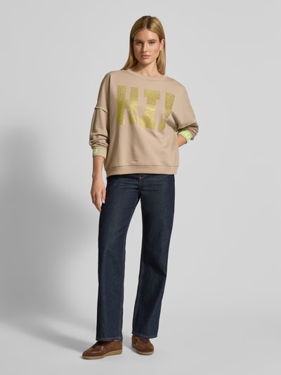 Kobiece model prezentuje Oversized Sweatshirt mit Label-Detail od miss goodlife, bawełna, krój oversized, prążkowane wykończenia, okrągły dekolt, detal z logo, widok całej sylwetki z przodu