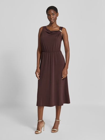 Vrouwenmodel draagt midi-jurk met asymmetrische cascadehals en siergesp van zero, materiaalmix met stretch, getailleerd model, ruglengte bij maat 36: 115 cm, geheel lichaamsaanzicht van voren