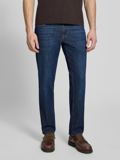 Männermodel trägt Slim Fit Jeans Modell 'ANGELS' von Guess, dunkles Blau, Baumwoll-Mix mit Stretch, Eingrifftaschen, Ganzkörperansicht von vorne.