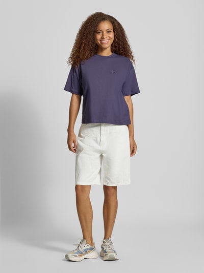 Frauenmodel trägt Regular Fit T-Shirt aus reiner Baumwolle Modell 'CHESTER' von Carhartt Work In Progress in Dunkelblau, Ganzkörperansicht von vorne. Damen T-Shirt, Stehkragen, Halbarm, Rückenlänge Größe S 56 cm.