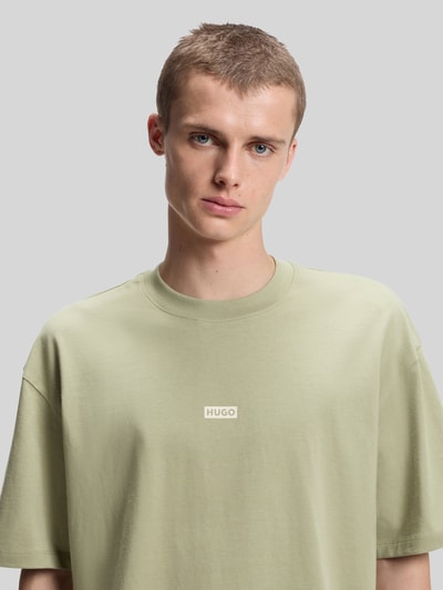 Männermodel trägt Relaxed Fit T-Shirts aus reiner Baumwolle von HUGO Blue in hellem Grün mit softer Textur, Nahaufnahme Oberkörper.