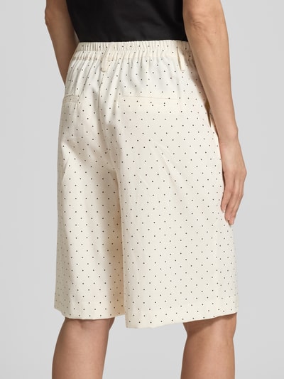 Frauenmodel trägt Bermudas im Allover-Look Modell 'Anja' von FREE/QUENT, cremefarben mit kleinen schwarzen Punkten, elastischer Bund, Paspeltaschen am Gesäß, weites Bein, Ganzkörperansicht Rückansicht.