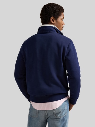 Männermodel trägt Relaxed Fit Troyer aus Baumwoll-Mix von Polo Ralph Lauren in Dunkelblau, Sweat-Optik, Ganzkörperansicht Rückansicht.