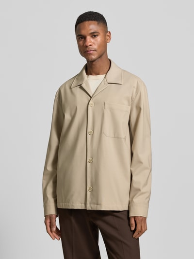 Männermodel trägt Hemdjacke aus Schurwoll-Elasthan-Mix mit Brusttasche von CRUNA in Beige, Regular Fit, Reverskragen, Ganzkörperansicht von vorne.