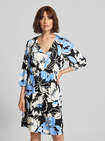 Frauenmodel trägt Knielanges Kleid aus Viskose im Allover-Look Modell 'Fe44li' von ZABAIONE mit floralem Muster in Blau, Schwarz und Weiß, A-Linie, V-Ausschnitt, 3/4-Arm, Ganzkörperansicht von vorne.