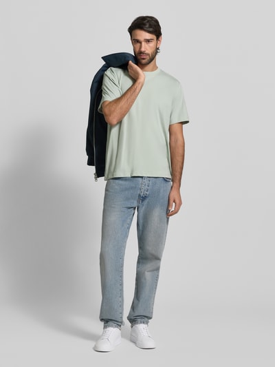 Męski model nosi Regular Fit T-Shirt aus reiner Baumwolle Modell 'ASPAN' od SELECTED HOMME, jasny zielony, jeansy, pełny widok z przodu.