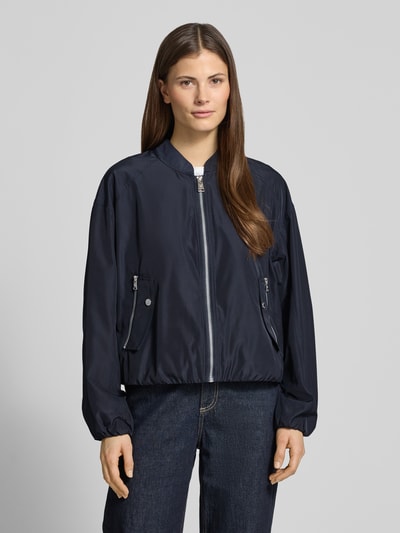 Modelka nosi Jacke mit Reißverschlusstaschen od Fuchs Schmitt, granatowa, krój regular fit, stójka, szerokość w rozmiarze 36: 54 cm, długość pleców: 52 cm, szerokość biustu: 57 cm, długość rękawa: 53 cm, z przodu, zbliżenie na górną część ciała.